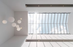 Modern interior design featuring a glass ceiling with a white structure and minimal lighting.