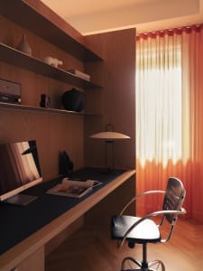 A modern minimalist home office with a wooden walls and desk, featuring a desk lamp and a chair.