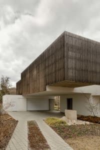 Modern residential building with wood facade and large windows.