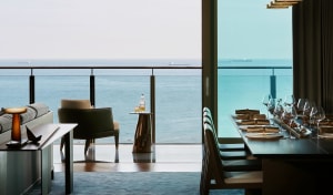 Modern dining room with glass windows overlooking the sea.