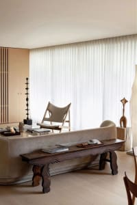 A modern living room featuring concrete walls and a leather sofa.