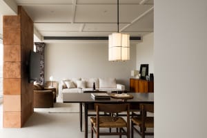 A modern minimalist living room featuring wooden furniture, white walls, and a white sofa with white cushions.