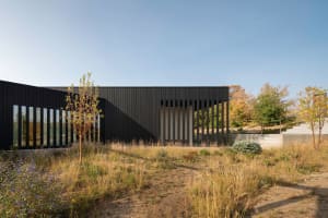 A modern contemporary exterior building facade with a metal-cladding and glass exterior design.