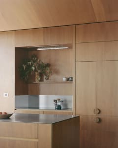 A modern, minimalist kitchen with wooden cabinets, stainless steel appliances, and a sleek design.