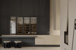 A modern minimalist mini kitchen with marble countertops and dark wooden cabinets.