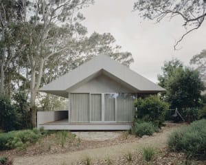 A minimalist residential house with a concrete exterior and large windows.