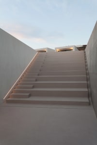 Concrete stairs with decorative lighting installed under the handrail.