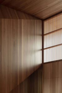 A modern minimalist interior featuring wooden paneled walls
