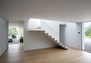 Modern interior with white concrete stairs and walls, featuring a minimalist design.