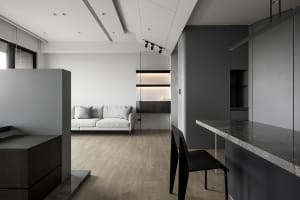 A minimalist living room featuring a concrete floor and wooden furniture.