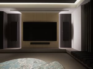 A modern media room featuring a large flat-screen TV, surround sound speakers, and wooden accents.
