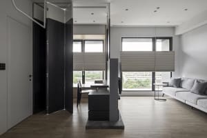 A modern living room featuring glass, wood, and fabric materials with a minimalist design.