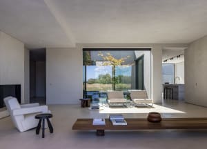 A minimalist living room with neutral materials and a view of the outdoors.