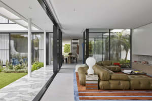 Well-lit, modern living room with a leather couch.