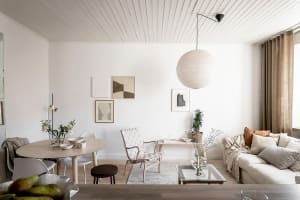 A contemporary living room with minimalist design, featuring timber furniture, a fabric sofa, and a glass coffee table.
