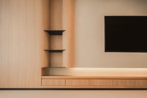 Minimalist living room featuring wooden shelves and a flat-screen television.