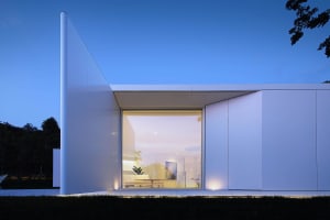 Modern minimalist exterior of a sleek metallic-clad building at dusk.