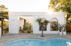Modern, minimalist house with a concrete exterior and poolside view.