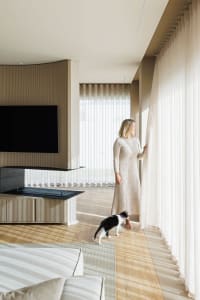 Modern interior design featuring a living room with white curtains, wood flooring, and minimalistic decor.