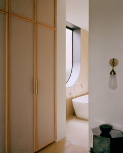 A minimalist bathroom with wooden paneling and concrete tiles.