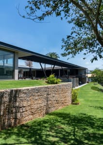 Modern residential home with concrete exterior and green landscaping.