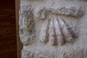 Ancient stone mural depicting a handprint with three fingers.