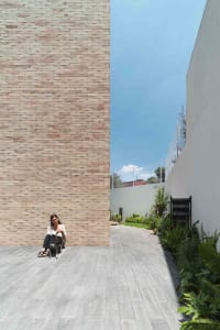 A modern residential exterior with concrete walls and a stone pathway.