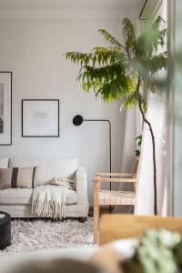 A minimalist living space featuring a couch, wall art, and a wooden bench.