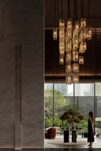 Modern hotel lobby featuring a glass chandelier hanging from the ceiling.