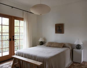 A minimalist bedroom with a bed made of cotton and linen blend sheets.