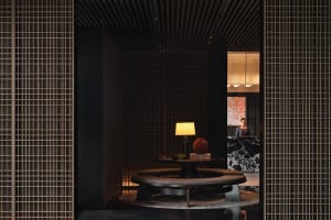 A modern hotel reception with a warm lighting setup, wooden furniture, and marble accents.