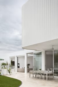 A modern residential home with a white prefabricated panel exterior.