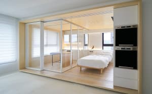 A modern minimalist living room featuring wood elements and a clean, open design.