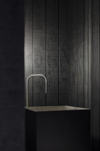 A modern metal sink with a minimalist, industrial design.