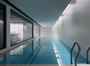 Swimming pool with concrete deck and minimalist design elements.