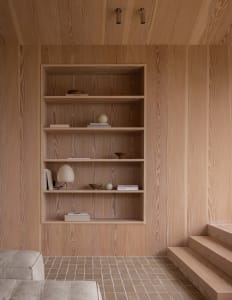 A minimalist room with wooden bookshelves and a tiled floor.