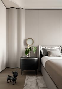 A modern minimalist bedroom with neutral tones, showcasing a sleek bed and smooth textures.