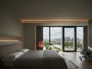 Spacious bedroom with hardwood flooring, large windows, and a view of the city.
