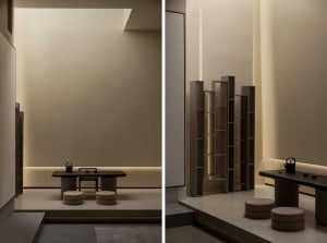 Minimalist teaching room with wooden table, concrete floor, and fabric stools.