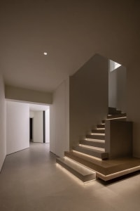 Modern minimalist staircase with concrete steps and wooden railings.