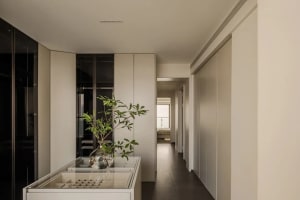 Modern residential interior featuring white walls, wooden flooring, and glass elements.