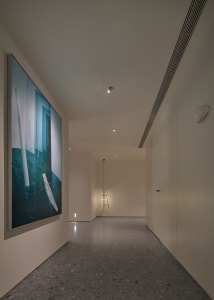Modern interior design featuring a corridor with concrete flooring and a painting depicting a sailboat.