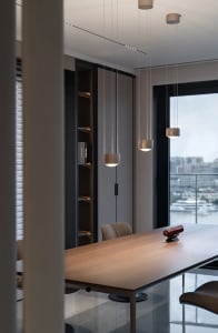 A modern industrial office space featuring a wooden table and metal chairs.