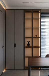 Modern, wooden bookshelf with built-in lighting and a small figurine on the shelf.
