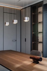 Modern-style dining room featuring a wooden table with a sculptural centerpiece.
