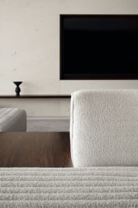 A modern living room with a cozy sofa upholstered in fabric.