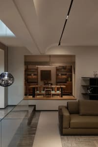 Modern minimalist living room featuring wooden furniture, leather accents, and glass elements.