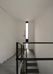 Modern staircase with black metal railings and concrete steps