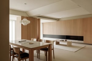 Modern interior design featuring marble dining table, wooden chairs, and concrete flooring.