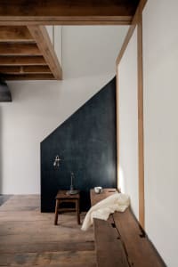 A minimalist interior with a wooden floor and light-colored furnishings.